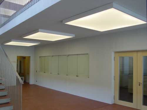 Eingang des Gemeindehauses Trun mit grossformatigen schallabsorbierenden Leuchten an der Decke